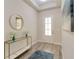Bright entryway with wood-look tile flooring, a console table, and an elegant round mirror at 2132 Limestone Trl, Kissimmee, FL 34747