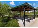 A community gazebo with benches provides a shaded spot amidst manicured greenery and blue skies at 2132 Limestone Trl, Kissimmee, FL 34747