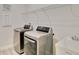 Updated laundry room with front-load washer, dryer, utility sink and wire shelving at 2132 Limestone Trl, Kissimmee, FL 34747