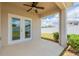 A covered back patio with a ceiling fan and view of the backyard with white fence at 3079 Bethpage Loop, Mount Dora, FL 32757