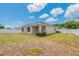 A view of the backyard, with the home's back side and a white fence at 3079 Bethpage Loop, Mount Dora, FL 32757