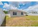 A view of the backyard with the home's back exterior and white fence at 3079 Bethpage Loop, Mount Dora, FL 32757