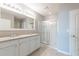 Bathroom showcasing double vanity, granite counters, and a glass-enclosed shower in a modern design at 3079 Bethpage Loop, Mount Dora, FL 32757