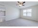 Bright bedroom with a ceiling fan, soft carpet, and a large window allowing for plenty of natural light at 3079 Bethpage Loop, Mount Dora, FL 32757