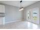Bright dining room with a modern light fixture and double doors that open to the backyard at 3079 Bethpage Loop, Mount Dora, FL 32757
