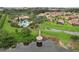 Scenic aerial view of community with clubhouse, pool, and tranquil lake at 4235 Prima Lago Dr, Lakeland, FL 33810