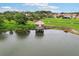 Scenic aerial view showcases a beautiful gazebo on a lake in a tranquil community with lush greenery and picturesque homes at 4235 Prima Lago Dr, Lakeland, FL 33810