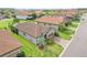 Overhead view of a gray home with a brick driveway, tropical landscaping, and a well-maintained lawn in a Gathering-friendly neighborhood at 4235 Prima Lago Dr, Lakeland, FL 33810