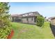 Spacious backyard featuring a screened patio, lush green grass, and manicured landscaping for outdoor enjoyment at 4235 Prima Lago Dr, Lakeland, FL 33810