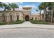 View of clubhouse exterior featuring an arched entryway, stone accents, and manicured landscaping at 4235 Prima Lago Dr, Lakeland, FL 33810
