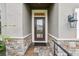 Home entryway with a stone base, glass-paned door and craftsman style light fixture at 4235 Prima Lago Dr, Lakeland, FL 33810