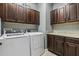 Laundry room features upper and lower cabinetry with granite countertops, and washer/dryer at 4235 Prima Lago Dr, Lakeland, FL 33810