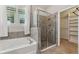 Bathroom featuring tiled shower, white tub and window at 4235 Prima Lago Dr, Lakeland, FL 33810