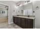 Bathroom features a dual vanity with granite countertops, dark wood cabinets, and a large mirror at 4235 Prima Lago Dr, Lakeland, FL 33810
