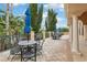 A covered patio with a table and chairs overlooking a landscaped area with palm trees and blue umbrellas at 4235 Prima Lago Dr, Lakeland, FL 33810