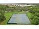 Aerial shot of community tennis and basketball courts bordered by mature trees and landscaping at 4235 Prima Lago Dr, Lakeland, FL 33810