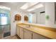 Bathroom featuring a long yellow counter with cabinets, large mirror, and adjacent toilet area at 932 Cassandra Ln, Lakeland, FL 33809