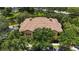 An aerial view of the building with a tile roof surrounded by lush green trees and landscaping at 504 Mirasol Cir # 102, Kissimmee, FL 34747