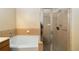 Bathroom featuring a glass door shower and a soaking tub with tile surround at 504 Mirasol Cir # 102, Kissimmee, FL 34747