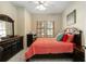 Comfortable bedroom with a dark wood dresser and a large window letting in lots of light at 504 Mirasol Cir # 102, Kissimmee, FL 34747