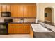 Kitchen with black appliances, warm wood cabinets, and a breakfast bar at 504 Mirasol Cir # 102, Kissimmee, FL 34747