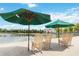 Relaxing outdoor seating area with umbrellas, rocking chairs, and a picturesque lakeside view at 504 Mirasol Cir # 102, Kissimmee, FL 34747