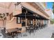 Outdoor seating area with black tables and chairs is shaded by umbrellas at the restaurant at 504 Mirasol Cir # 102, Kissimmee, FL 34747
