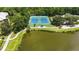 Aerial view of tennis courts next to a pond with an adjacent path and verdant landscape at 504 Mirasol Cir # 102, Kissimmee, FL 34747