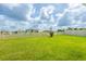Expansive backyard with healthy green grass, white picket fence, and a clear blue sky at 5934 Shingle Creek Rd, Lakeland, FL 33811