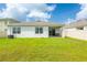 A backyard features a manicured lawn, sliding glass doors, and a covered patio perfect for outdoor seating at 5934 Shingle Creek Rd, Lakeland, FL 33811