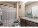 Clean bathroom featuring a shower with gray striped curtain, granite countertop, and decorative accents at 5934 Shingle Creek Rd, Lakeland, FL 33811