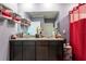 Well-lit bathroom featuring a double sink vanity, large mirror, and a decorative shower curtain at 5934 Shingle Creek Rd, Lakeland, FL 33811