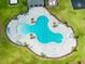 Aerial view of a modern community pool and sunbathing area, surrounded by lush landscaping at 5934 Shingle Creek Rd, Lakeland, FL 33811