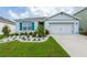 Charming single-Gathering home with vibrant blue shutters, well-manicured landscaping, and a two-car garage at 5934 Shingle Creek Rd, Lakeland, FL 33811