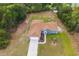 Aerial view of a one-story home with a brown roof, blue siding, and an attached garage in a neighborhood with mature trees at 8628 Sw 133Rd Lane Rd, Ocala, FL 34473