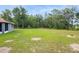 A view of the backyard shows young planted trees and green grass at 8628 Sw 133Rd Lane Rd, Ocala, FL 34473