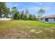 A large backyard with young planted trees and a house with solar panels at 8628 Sw 133Rd Lane Rd, Ocala, FL 34473