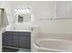 Bright bathroom featuring double sinks, a large mirror, and a soaking tub by a window at 8628 Sw 133Rd Lane Rd, Ocala, FL 34473