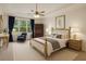 Bright bedroom with a comfortable bed, a large window with blue curtains, and elegant decor at 8628 Sw 133Rd Lane Rd, Ocala, FL 34473