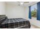 Bedroom with a sleek black bed, ceiling fan, and large window offering natural light at 8628 Sw 133Rd Lane Rd, Ocala, FL 34473