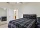 Bedroom featuring a black bed, ceiling fan, and mirrored closet door, creating a spacious feel at 8628 Sw 133Rd Lane Rd, Ocala, FL 34473