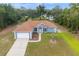 Aerial view of a one-story home with a brown roof, blue siding, an attached garage, and landscaped front yard at 8628 Sw 133Rd Lane Rd, Ocala, FL 34473