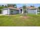 Front view of a one-story gray home featuring a two car garage, and a well-manicured lawn at 8628 Sw 133Rd Lane Rd, Ocala, FL 34473