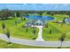 Aerial view showcasing the home, a serene pond, and meticulously maintained landscaping, exemplifying luxury and privacy at 12902 Sw 138Th Loop, Dunnellon, FL 34432