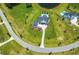 Stunning aerial view of luxury home with a sparkling pool, surrounded by lush green lawns and a picturesque pond at 12902 Sw 138Th Loop, Dunnellon, FL 34432