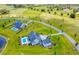 Expansive aerial shot showcases a beautiful home with pool, complemented by sprawling green fields and winding driveway at 12902 Sw 138Th Loop, Dunnellon, FL 34432