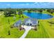 Aerial view of pristine home with a sparkling pool, nestled next to a serene lake and manicured lawns at 12902 Sw 138Th Loop, Dunnellon, FL 34432