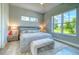 Relaxing bedroom featuring ample natural light, a comfortable bed, stylish furniture and a large picturesque window at 12902 Sw 138Th Loop, Dunnellon, FL 34432