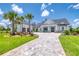 Beautiful home with a long driveway lined with palm trees, a detached garage, and lush landscaping enhancing its curb appeal at 12902 Sw 138Th Loop, Dunnellon, FL 34432