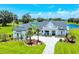 Stunning home with a white exterior, meticulous landscaping, complemented by a serene lake view at 12902 Sw 138Th Loop, Dunnellon, FL 34432